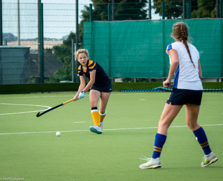 1st & 2nd X1 v Strathallan. Pupils playing hockey on court, agents each other. One player dribbling with the ball to on coming pupil.