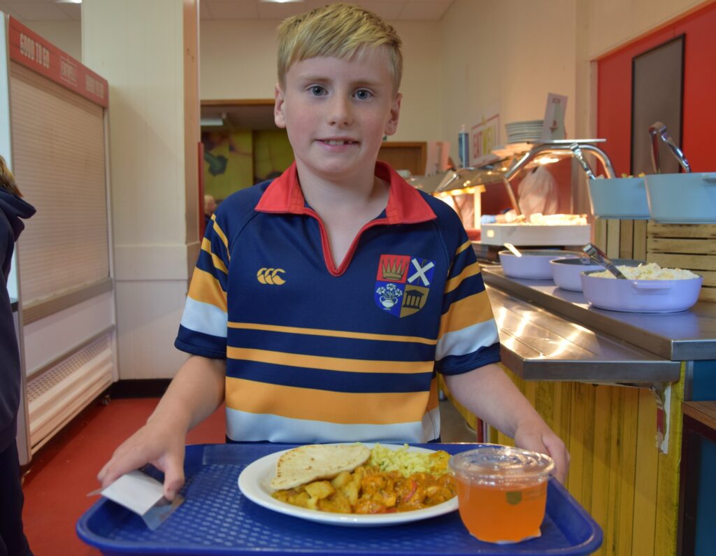 Junior Years pupil with lunch in Dining Hall