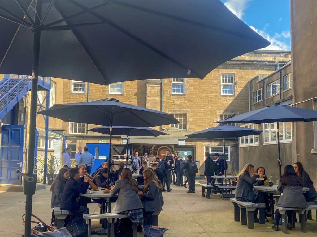 Senior Years pupils sit on picnic tables outside The Pod