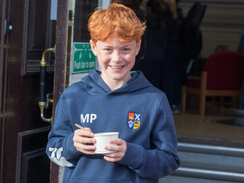 Junior pupil enjoys food on steps of Margaret Harris Building